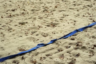 Borken-Hoxfeld, NRW, Germany, A stretch of sandy beach shows blue tape running across, marking a