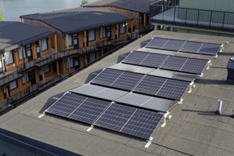 Solar panels on roof of apartment building, renewable green sustainable energy concept, water