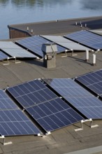 Solar panels on roof of apartment building, renewable green sustainable energy concept, water