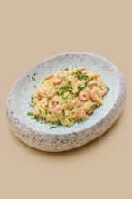 A creamy dish of risoni pasta combined with tender shrimp and fresh herbs is presented in an