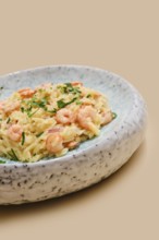 A delicious dish of risoni pasta is topped with tender shrimps and sprinkled with fresh herbs. This