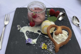 Dessert sweet dish cherry mousse with vanilla ice cream and heart-shaped pastry, international