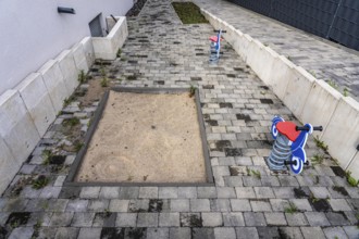 Playground at a multi-family residential building in Bochum, small sandpit, 2 spring seesaw toys,