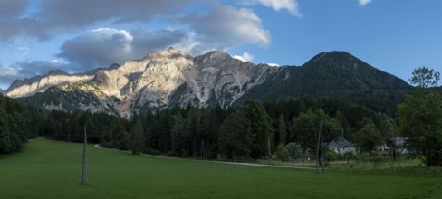 The warm evening sun falls on the steep rock faces of the Kamnik-Savinjer Alps near Zgornje