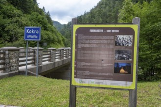 Information board with historical photos at the bridge over the Kokra River in the valley of