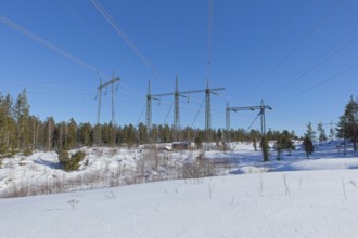 High-voltage power lines in sunny winter weather with snow on the ground, Loviisa, Finland
