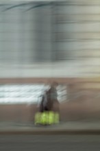 Abstract of a woman walking in front of a building captured using ICM intentional camera movement
