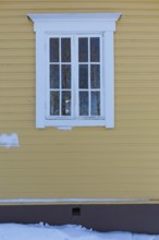 White framed wooden window on a yellow painetd wall, Suurikylä, Finland