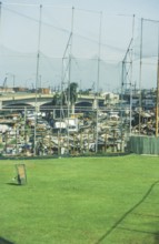 Green lawn of a sports field, slums behind it, Manila in 1995, Philippines