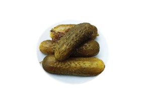 A plate of salted and crispy cucumbers and a sprig of dill