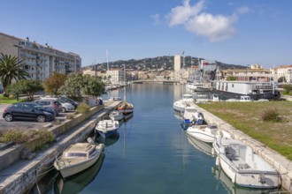 View from Pont des Dockers across the Canal de la Peyrade with moored boats along the quays towards