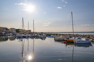 Atmospheric sun reflection on the quiet water surface of the harbor basin in La Pointe Courte, seen