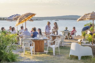 Summer scene on the terrace of the Guinguette A la bonne Franquette with guests sitting at tables