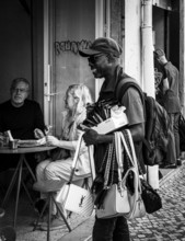 Black and white photography, street art, retailer offering his goods, Lisbon, Portugal