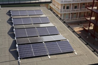 Solar panels on roof of apartment building, renewable green sustainable energy concept, water