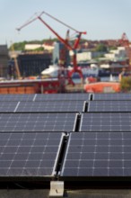 Solar panels on roof of apartment building, renewable green sustainable energy concept, water