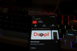 Smartphone displaying Doppl app on Google Play in front of a lit keyboard