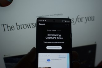 A smartphone displaying a ChatGPT Atlas announcement on its screen