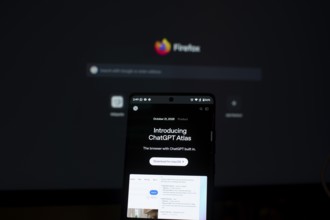 ChatGPT Atlas displayed on a smartphone with a Firefox screen in the background