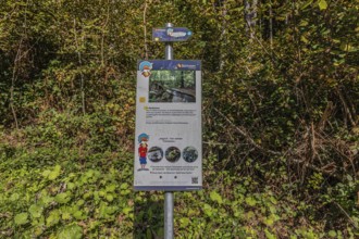 Information board of the artificially created water channel that used to power the historic oil