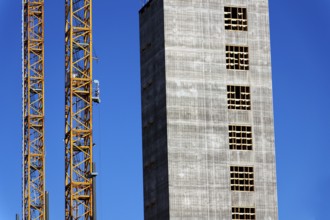 Two yellow cranes on skyscraper construction site of timber building Kaj 16 with hybrid concrete
