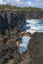 Massive, black lava cliffs rise steeply out of the Indian Ocean at Cap Mechant, where white surf