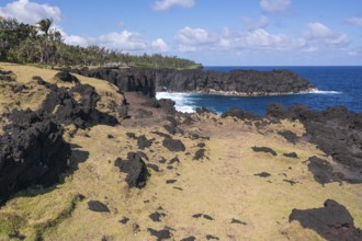 The barren lava coast at Cap Mechant with black lava cliffs and boulders, here and there with