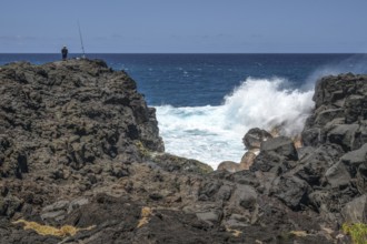 Thundering surf washes around the black lava cliffs of the south coast of the Indian Ocean, very