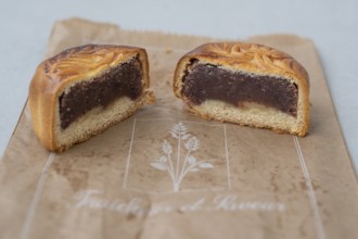 Close-up of a mooncake (mooncake) cut in the middle with a thick layer of dark red bean paste and a