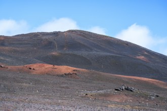 The Route du Volcan leads through the vast, black volcanic desert of the Plaine des Sables, where a