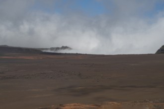 The Route du Volcan leads through the vast, rust-red lunar landscape of the Plaine des Sables,