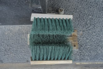 Broom at the entrance to the house, device for cleaning shoes in winter, Helsinki, Finland