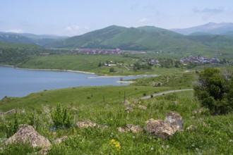 Wide view of a lake surrounded by green hills and mountains under a blue sky, Kechut, Kushchi,