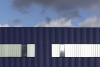 Blue corrugated iron façade with windows, blue sky, graphic, warehouse, logistics hall