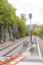 Railway tracks next to rocky embankment and trees, autumn landscape, signal building on the Hermann