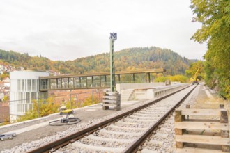Railway tracks on a viaduct surrounded by autumn trees and buildings, signal building on the