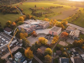 Modern Maria von Linden Gymnasium school building in autumn landscape at sunset, captured by drone,