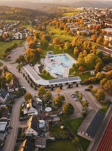 Bird's eye view of swimming pool in the middle of an autumn village, Calw, Black Forest, Germany