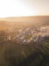 Village and fields in morning fog with warm shades of sunrise light, Calw Stammheim, Black Forest,