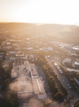 Urban industrial area in morning fog illuminated by warm sunlight, Calw Stammheim, Black Forest,