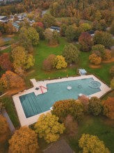 Small pond in an autumn park surrounded by colorful trees and trails, Sindelfingen, Böblingen