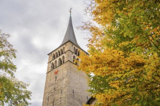 View of a tall church tower overshadowed by golden leaves, Sindelfingen, Böblingen district,