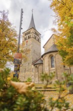 Old church building surrounded by yellow autumn leaves, Sindelfingen, Böblingen district, Germany