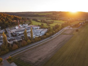 Industrial area at sunset next to fields and road in rural area, Aidlingen, Böblingen district,