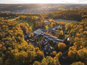 Motherhouse building in autumn landscape with sunset and village in background, Aidlingen,