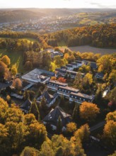 Sunlight illuminates motherhouse buildings and autumn trees in rural surroundings, Aidlingen,