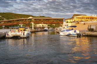 Several boats and catamarans are moored on the jetty in the port of Saint-Gilles, whose water