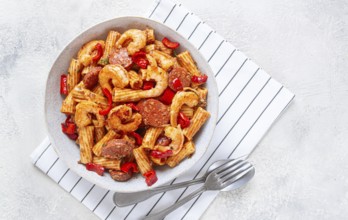 Jambalaya pasta with shrimp and sausages, cooked with bell pepper in a frying pan, homemade, on a