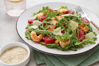 Fresh shrimp salad with arugula, grapefruit, and parmesan served in a bowl
