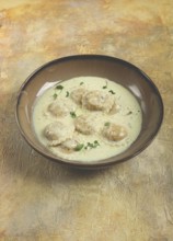 Ravioli in cream sauce, spices and herbs, top view, no people